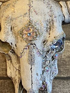 an elephant's head is adorned with jewels and beads on the wooden wall behind it