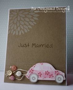 a card with a pink car and buttons attached to the front, on a white background