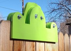 a green sculpture on top of a wooden fence