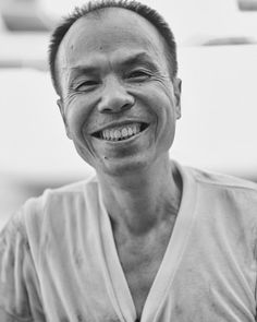 a black and white photo of a man smiling