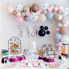 a table topped with lots of desserts and balloons