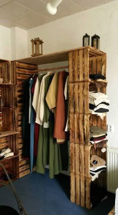 an open closet with clothes hanging on wooden shelves