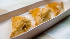 three pastries sitting in a white dish on a table