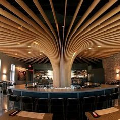 the interior of a restaurant with wooden ceilinging and bar stools in front of it