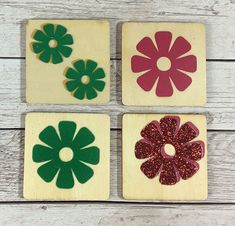 four wooden coasters with flowers painted on them