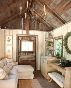 a living room filled with furniture and a wooden ceiling covered in wood planks next to a doorway