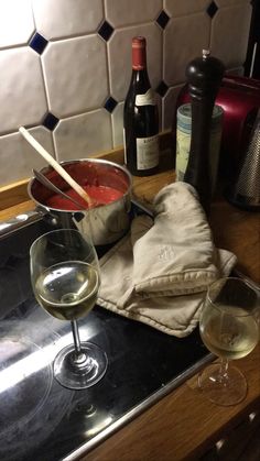 two glasses of wine sitting on top of a kitchen counter