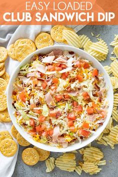 an easy loaded club sandwich dip in a bowl surrounded by crackers