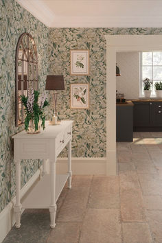 the hallway is decorated with wallpaper and pictures on the walls, along with a white console table