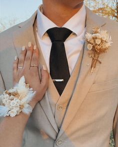 a man in a suit and tie with flowers on his lapel flower cufflinks