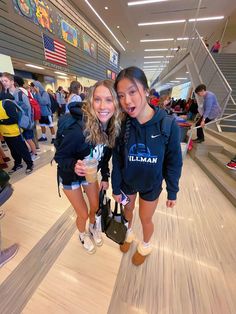 two girls are standing on the bowling alley