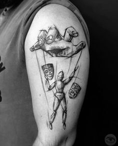 a man with a tattoo on his arm holding onto an object in the shape of a parachute