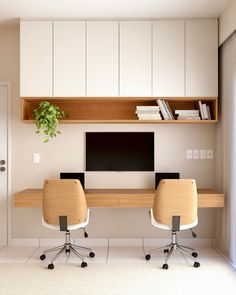 an office with two desks and a computer monitor on the wall above them is shown