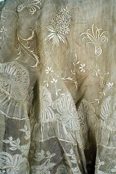 an old lace curtain with white flowers on it