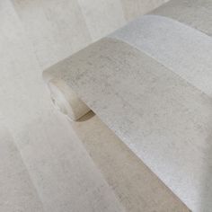 a roll of toilet paper sitting on top of a white floor next to a wall