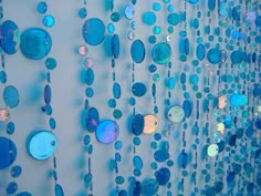 a wall with many different colored circles hanging from it's sides and on the side