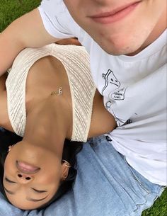 a man laying on the ground with his arm wrapped around a woman's head