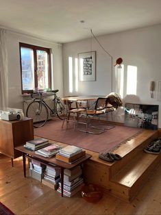 a living room filled with furniture and a fire place next to a bike parked on the wall