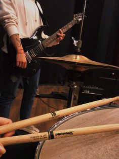 a person playing drums in front of a set of drumsticks and drum sticks