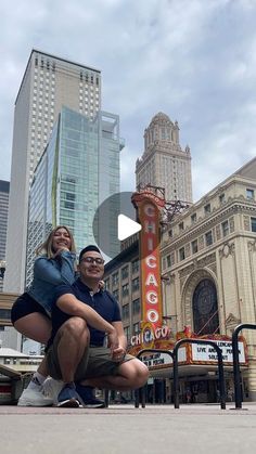 a man and woman pose in front of the chicago theatre