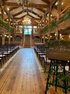 an indoor wedding venue with wooden floors and chandelier hanging from the rafters