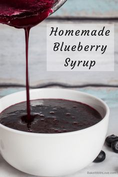 homemade blueberry syrup being poured into a white bowl