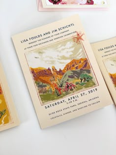 three wedding programs are displayed on a table with flowers and other items in the background