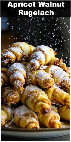 a pile of pastries sitting on top of a plate covered in powdered sugar