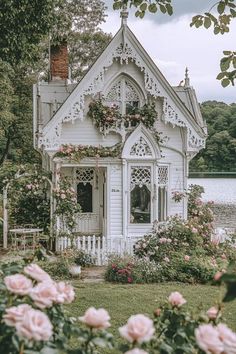 a white house with pink roses around it