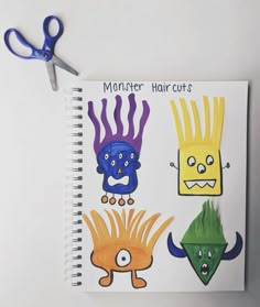 an open notebook with cutouts of monsters and hair cuts on it, sitting next to a pair of scissors