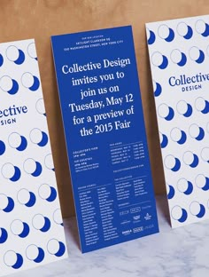 three blue and white posters on a marble counter top with the words collective design written below them