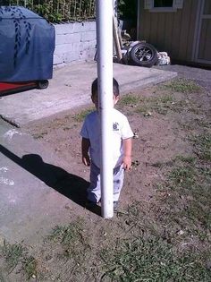 a little boy standing next to a street sign