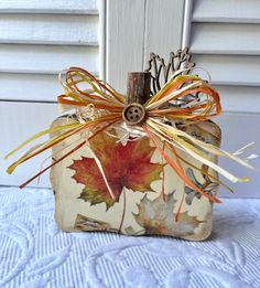 a decorative pumpkin decorated with autumn leaves