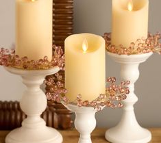 two white candle holders with pink flowers on them