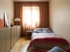 a bed sitting in a bedroom next to a window