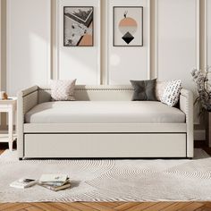 a white daybed sitting on top of a hard wood floor next to a wall