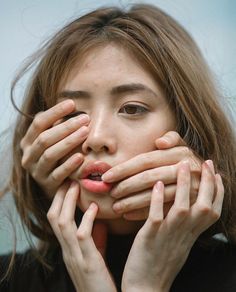 a woman covering her face with both hands