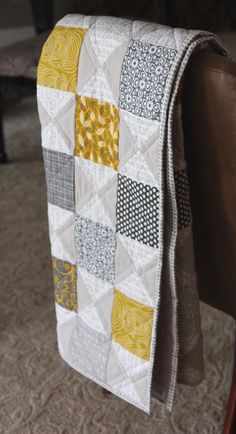 the back of a chair with a quilt on it