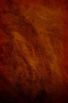 an orange and brown background textured with some sort of paint or stain on the surface