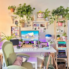 a desk with a computer and some plants on it