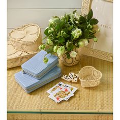 a table topped with cards and flowers next to a potted plant