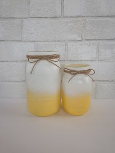 two jars with yellow liquid are sitting next to each other