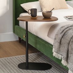 a bed with a green headboard and a table on it next to the bed