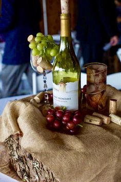 a bottle of wine sitting on top of a table next to glasses and corks