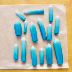 some blue glass pieces are laying on a piece of paper and placed on a table