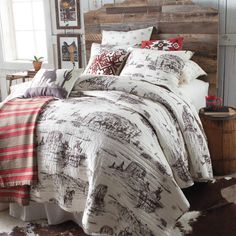 a bedroom with a bed covered in a white and brown comforter