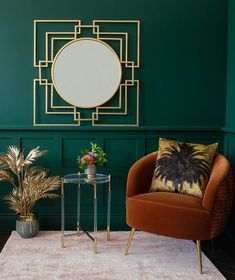 a living room with green walls and a round mirror on the wall above a small table