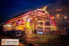 a brightly lit glass building with lights on it