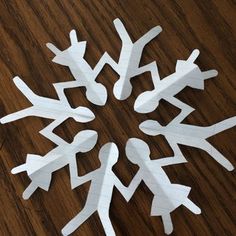 several white snowflakes sitting on top of a wooden table