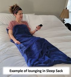 a woman laying in bed with a blue blanket on top of her and text example of lounging in sleep sack